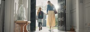 Mom and daughter walking out their door to go to school